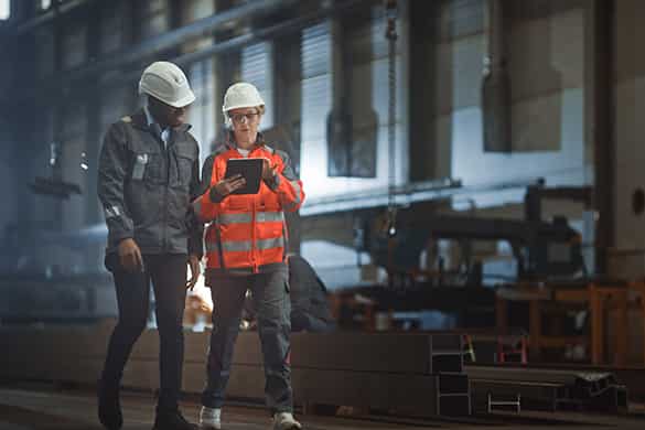 construction workers looking over a project plan while on a busy worksite